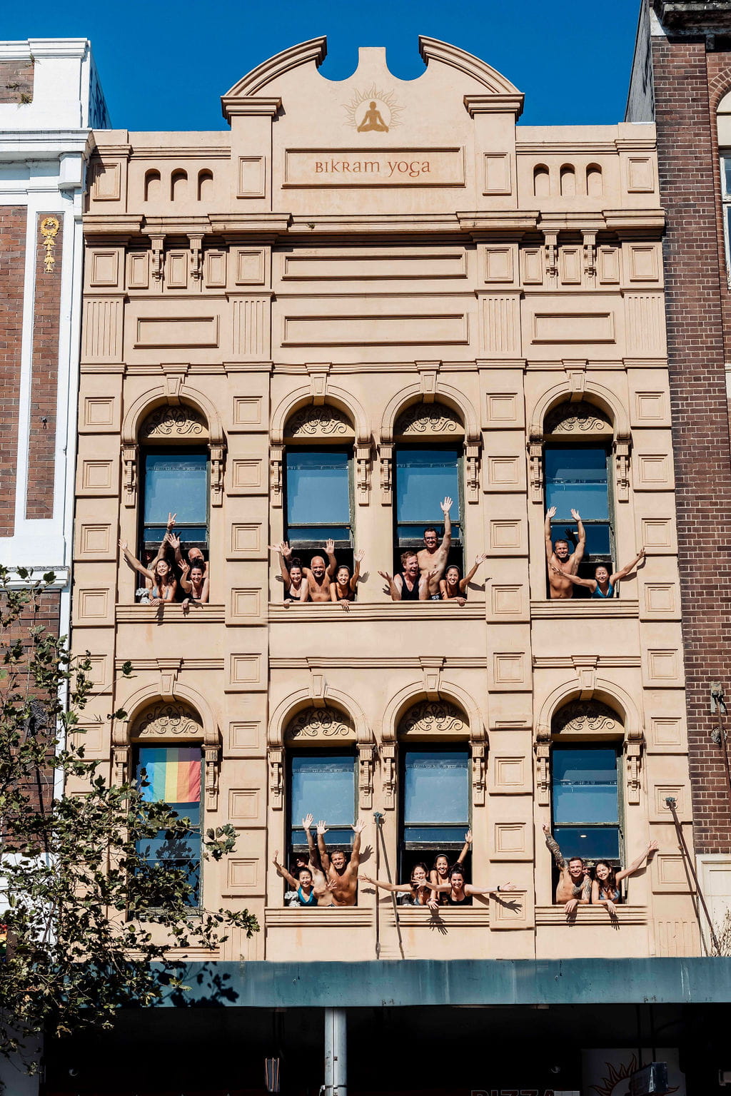 Students waving from the studio's windows above Oxford Street