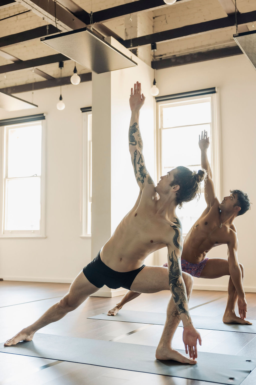 Two students in triangle pose in the hot room